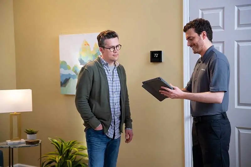 Dealer and man with ipad by thermostat